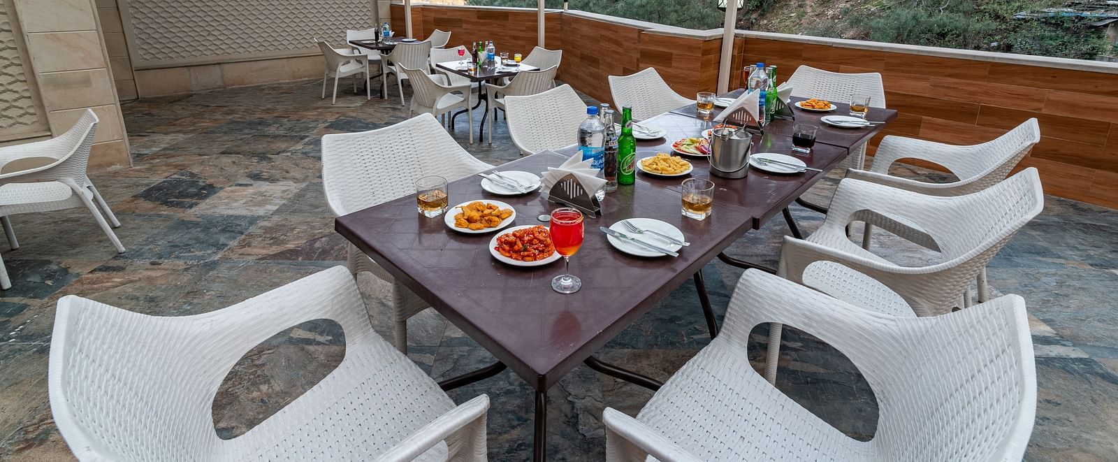 A terrace with a dining setup, featuring a sheet-covered top and offering stunning mountain views at DLS Hotels The Rock Castle.